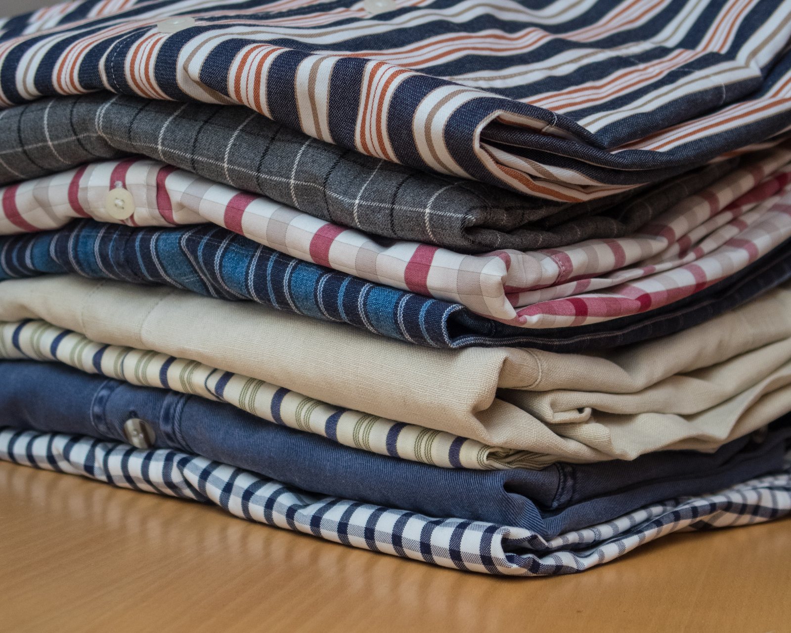 Stack of folded cotton shirts in stripes, checks and chambray
