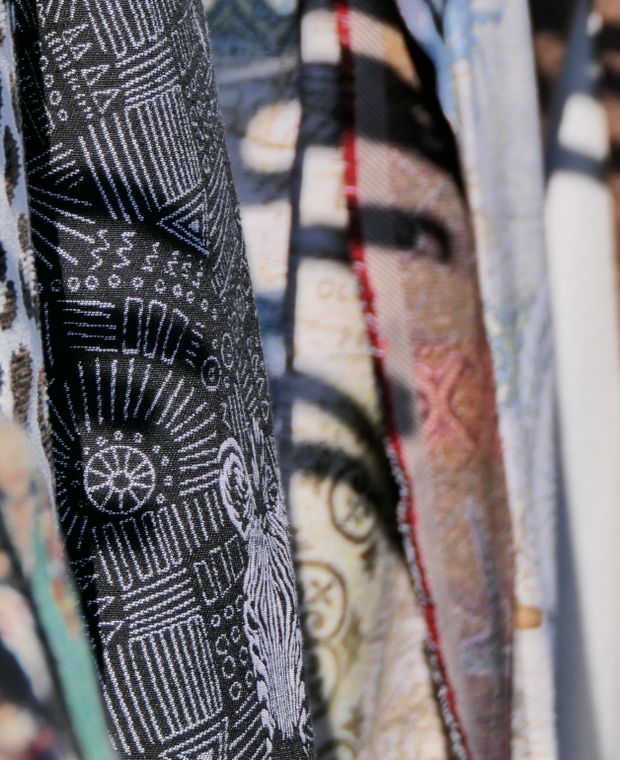 Printed fabrics hanging side by side, a black and white geometric print in the foreground