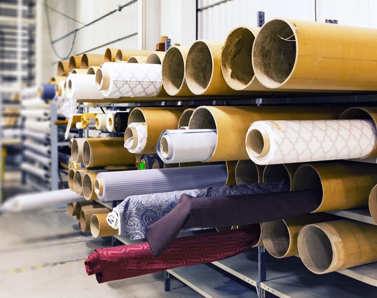 Rolls of finished and printed fabric stored on warehouse racks