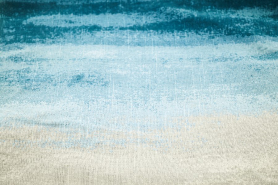Blue printed cotton fading from deep teal to pale sky blue and ecru
